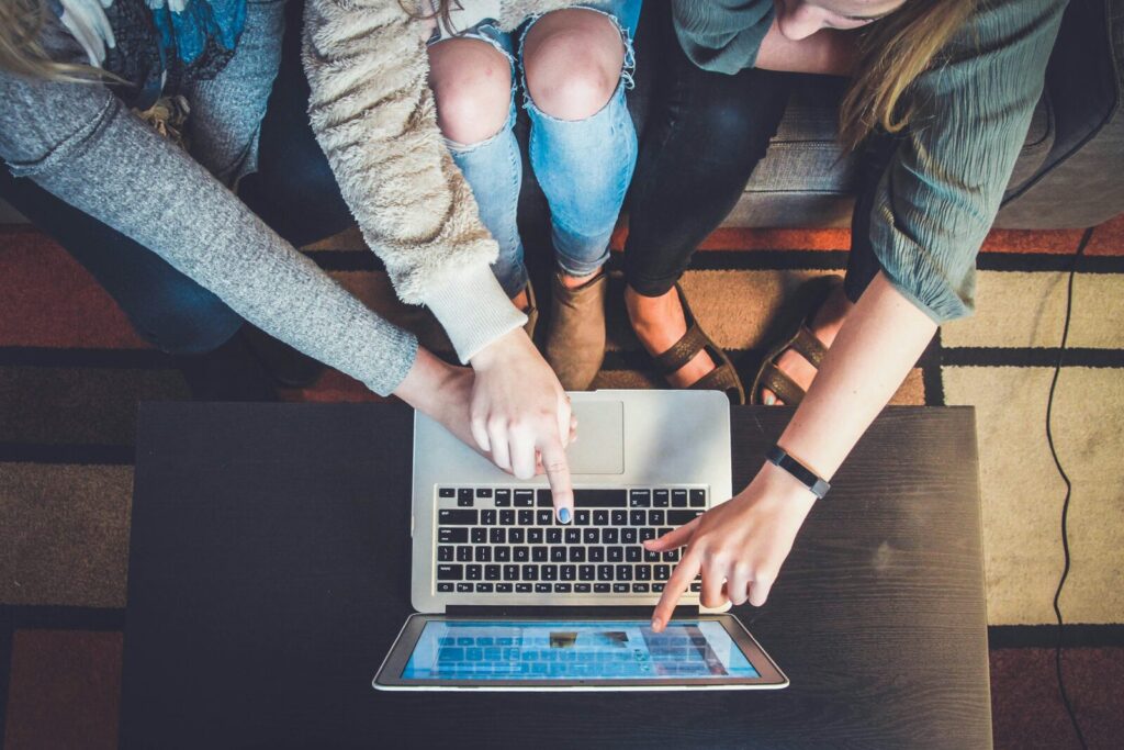 Trois personnes consultent un ordinateur portable